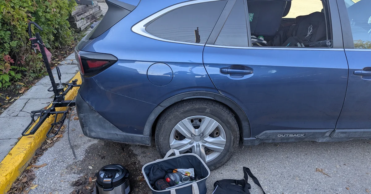 Blue Subaru Outback with broken window after car break-in